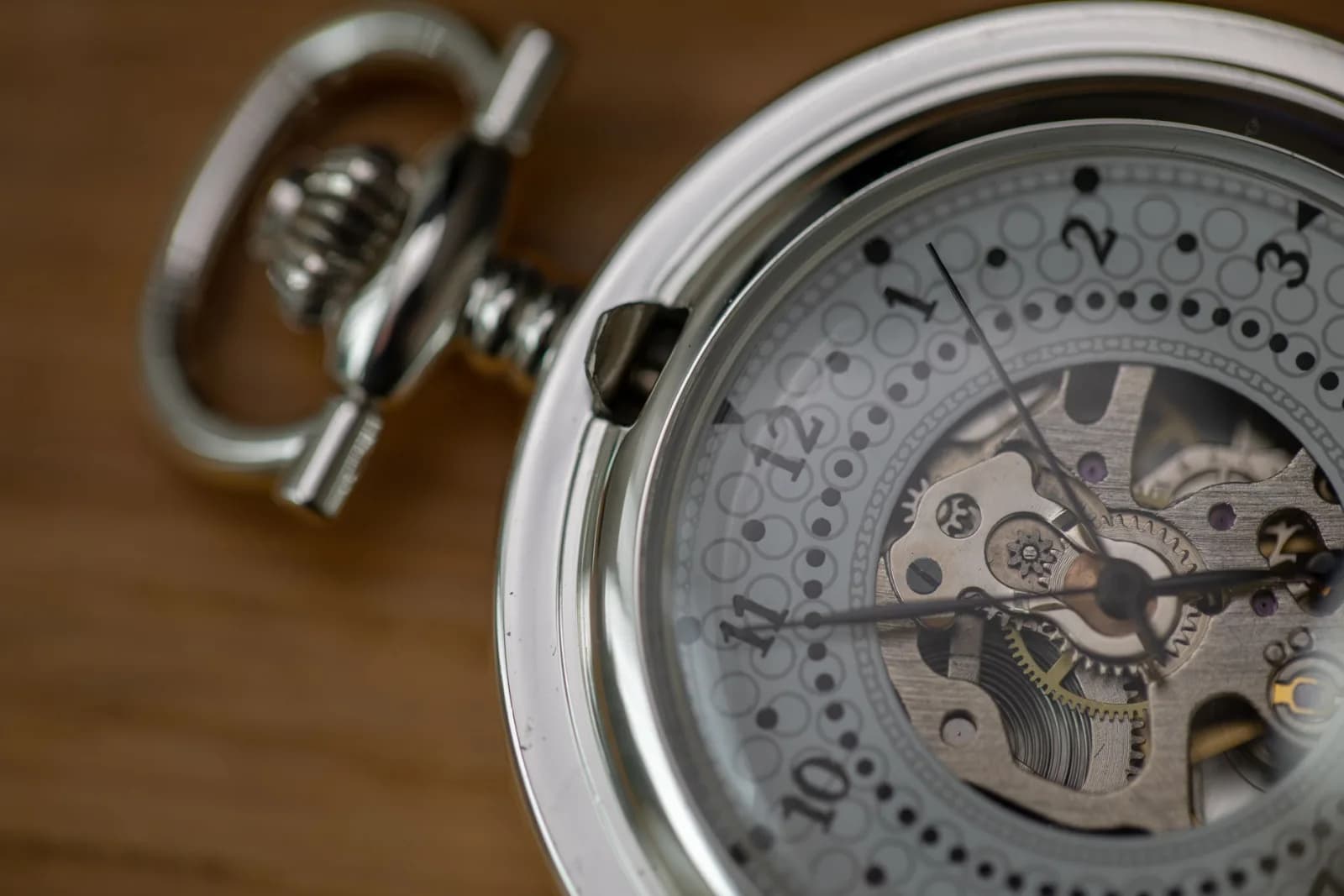 Detailed close-up of a silver skeleton pocket watch showcasing intricate gears and design.