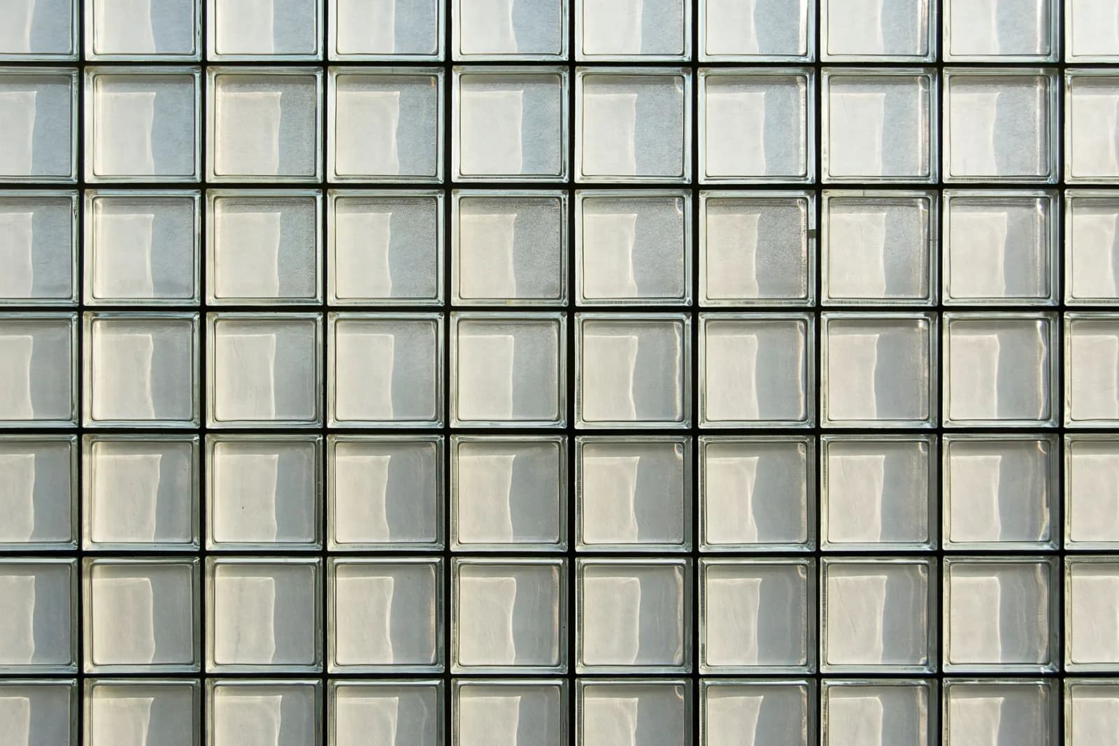 Close-up of a geometric glass block facade showcasing a repetitive pattern and modern architecture.