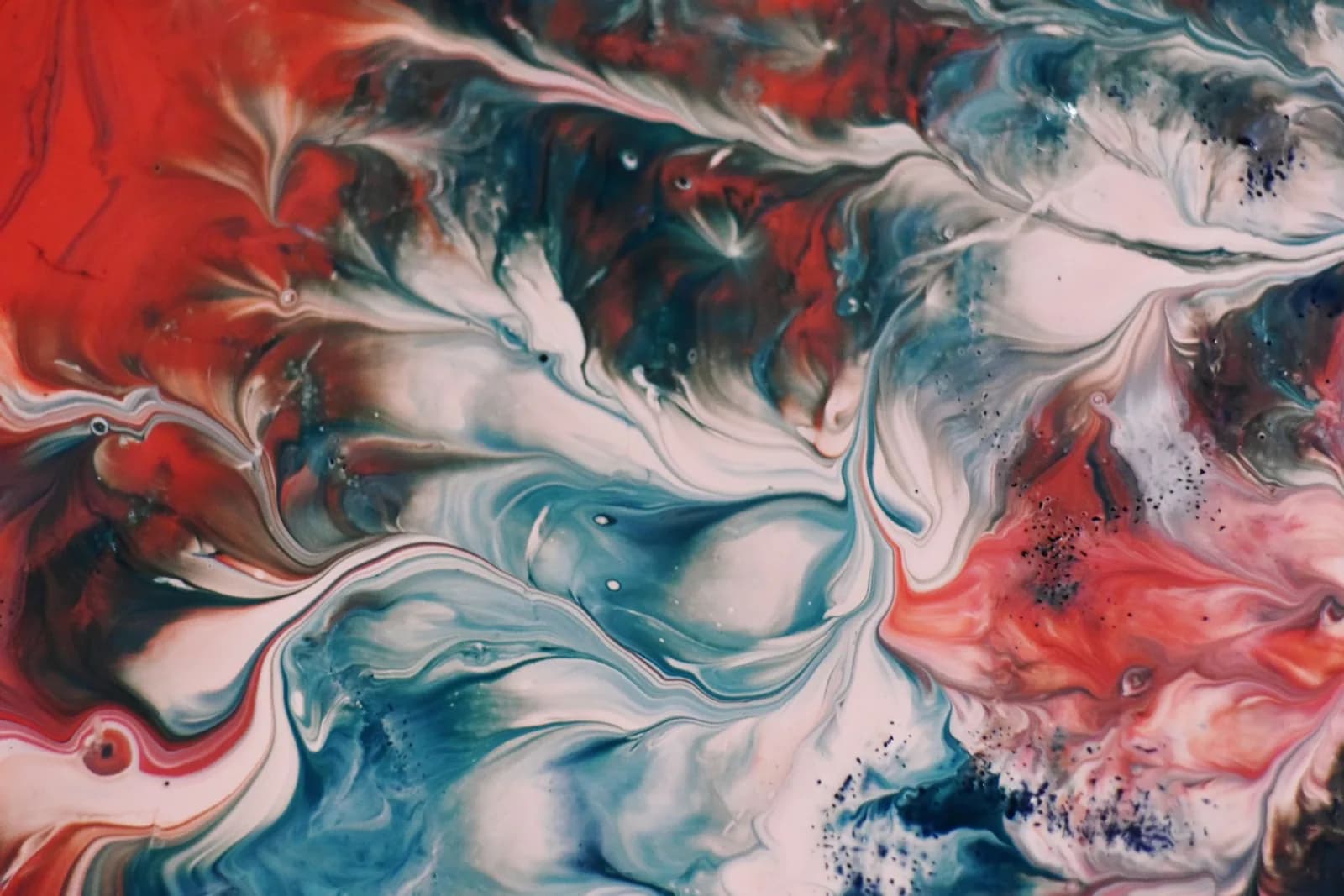 Dynamic fluid painting with vibrant swirls of red, blue, and white, showcasing modern abstract art.