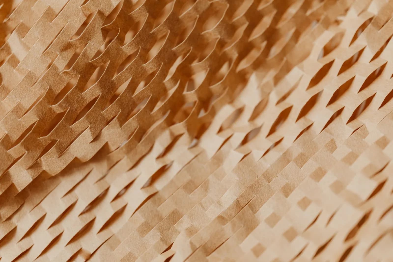 Close-up of a textured, abstract pattern in beige paper, creating a warm, artistic visual.