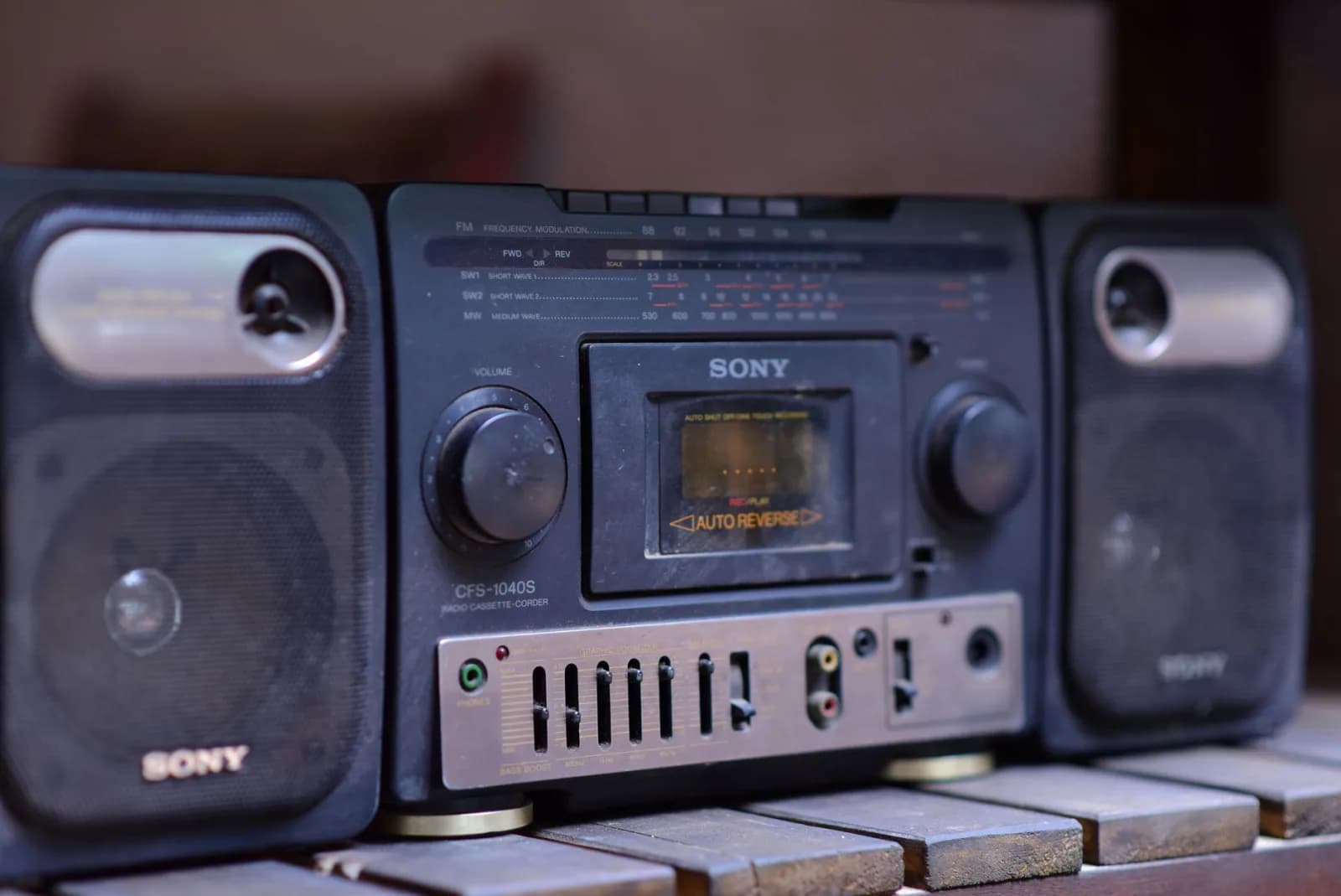 Close-up of a vintage Sony boombox cassette player with speakers on a wooden surface.