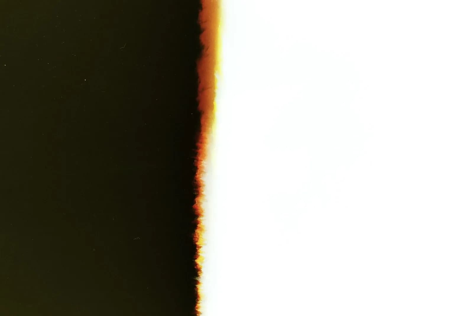 An abstract image showcasing a burnt film effect with a stark contrast between dark and light.