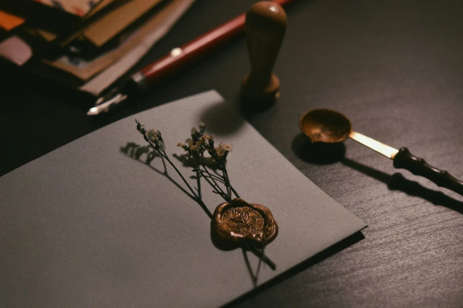 A vintage letter with wax seal and flowers on a desk, evoking nostalgia.