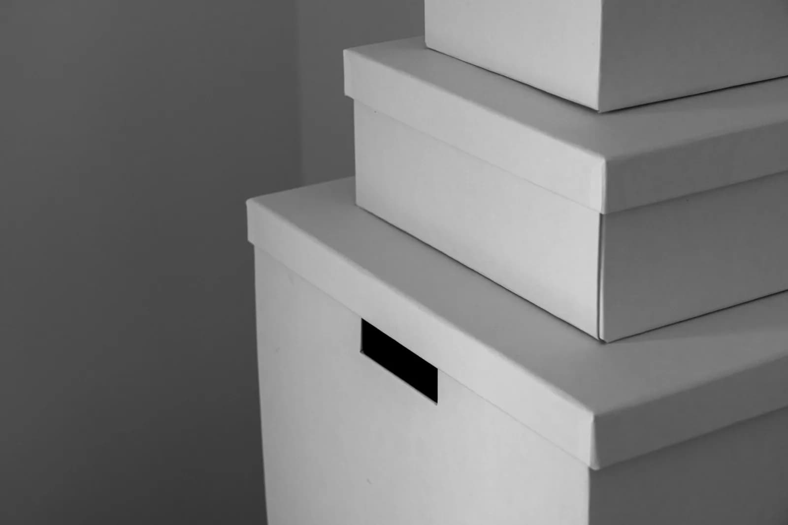 Minimalist close-up of white storage boxes stacked indoors. Perfect for organization themes.