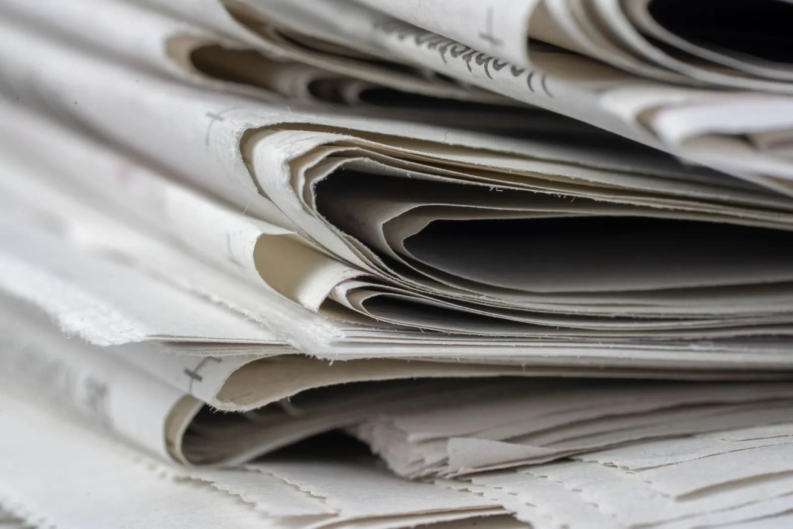 A detailed close-up view of stacked newspapers, highlighting textures and layers.