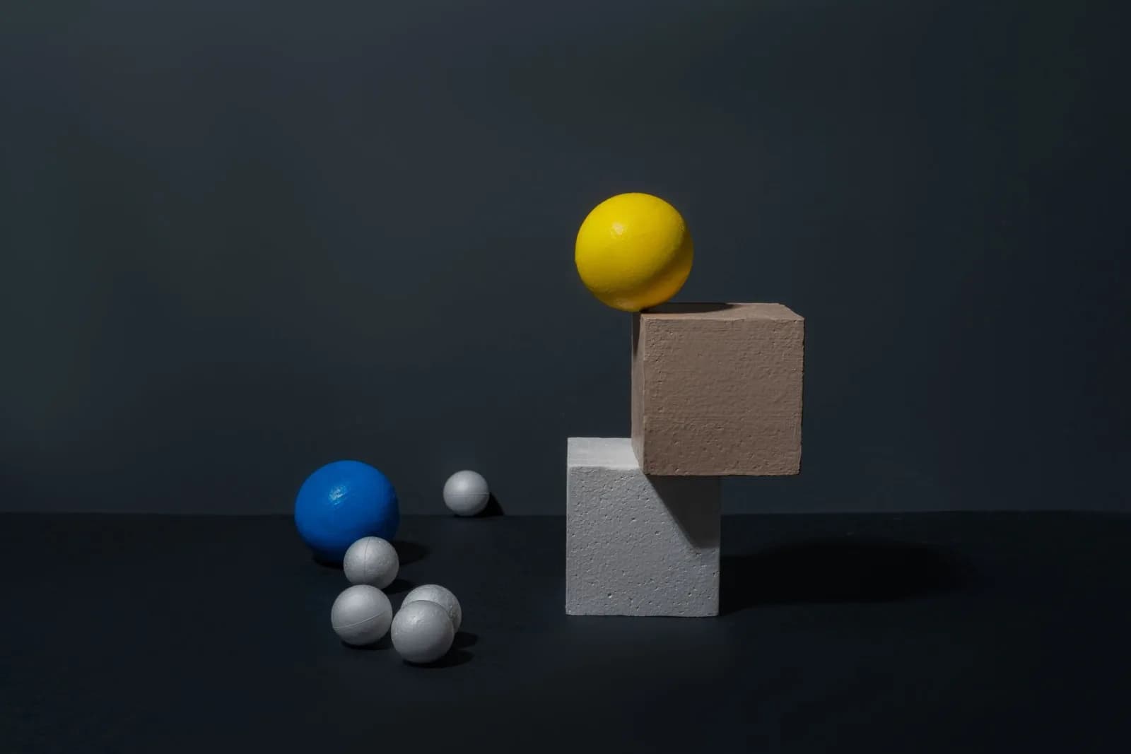 Modern still life with colorful geometric shapes on a dark background, ideal for design projects.