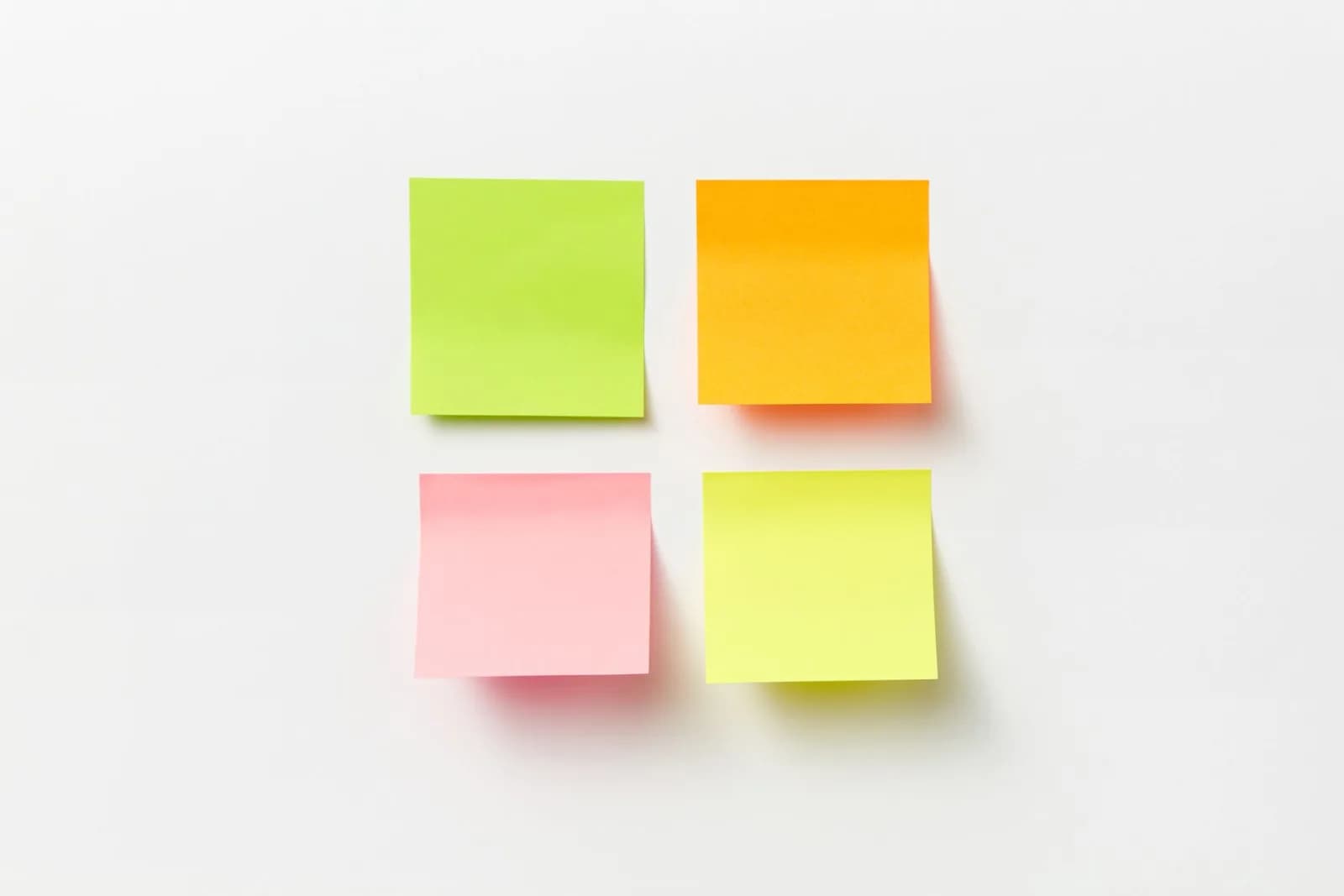 Four colorful sticky notes arranged on a clean white background.