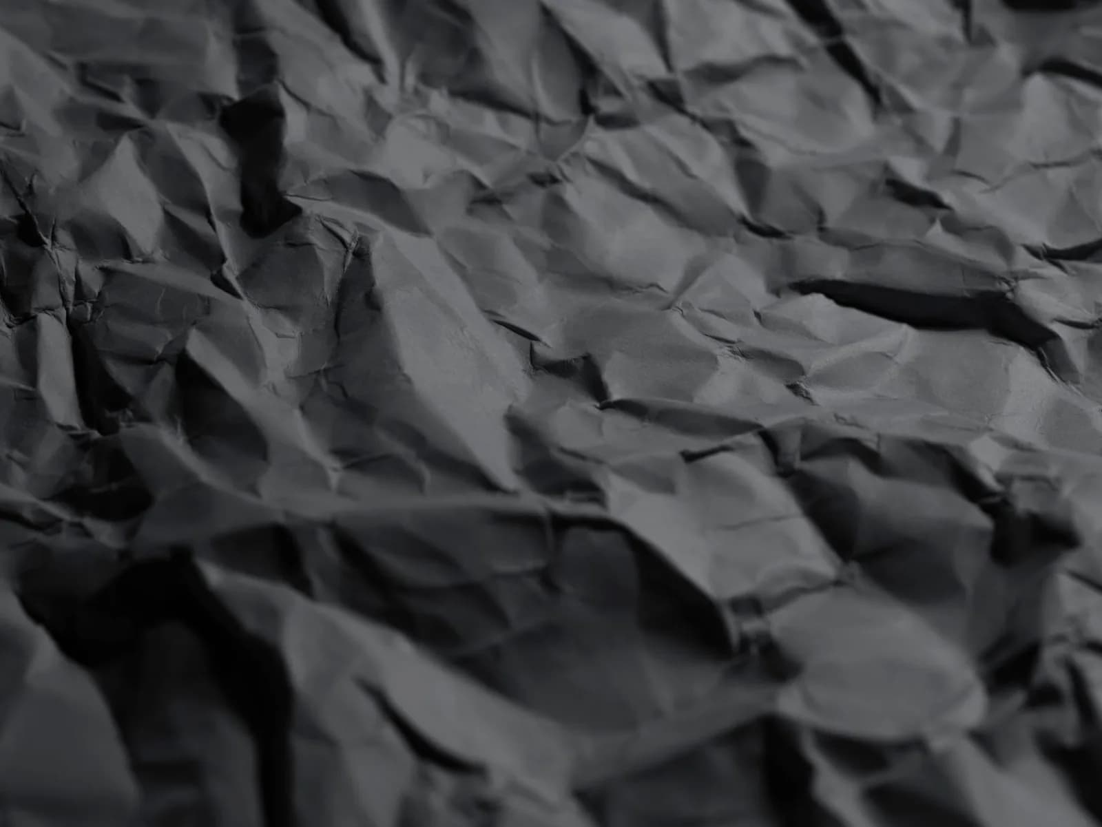 Detailed close-up of crumpled black paper texture for backgrounds and design projects.