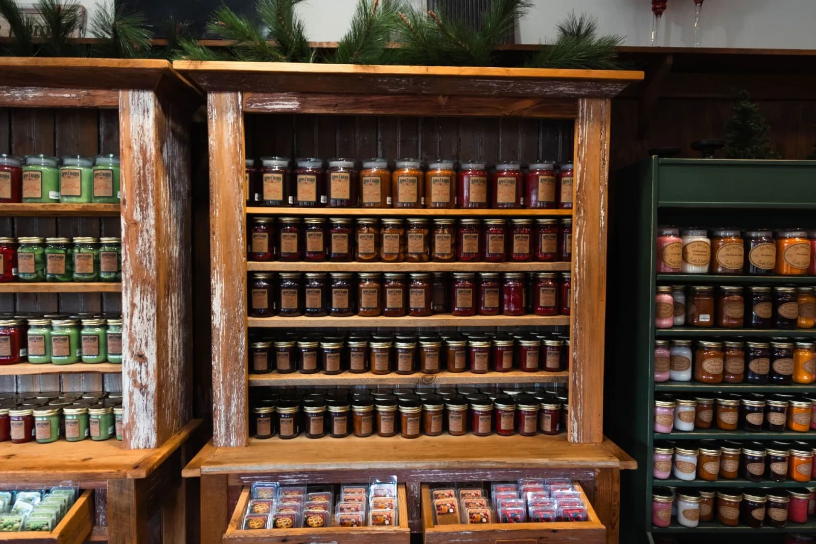 Rustic wooden shelves displaying a variety of jarred products in a cozy store setting.