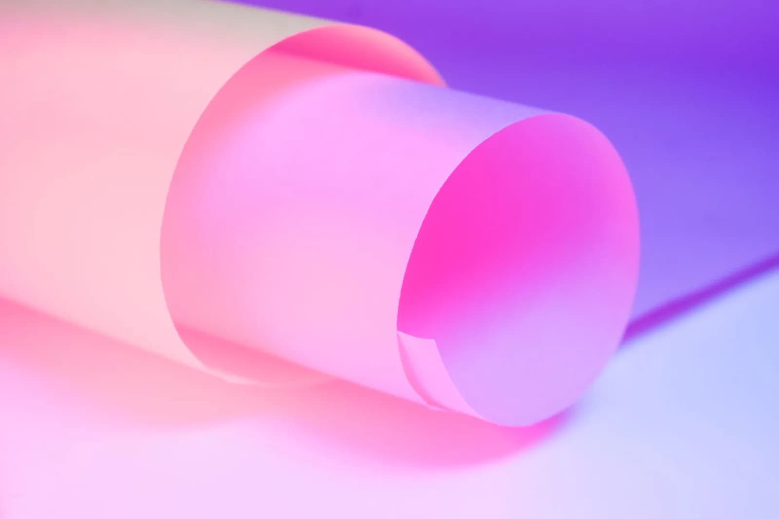 A vivid abstract art of rolled paper with gradient pink and purple hues.