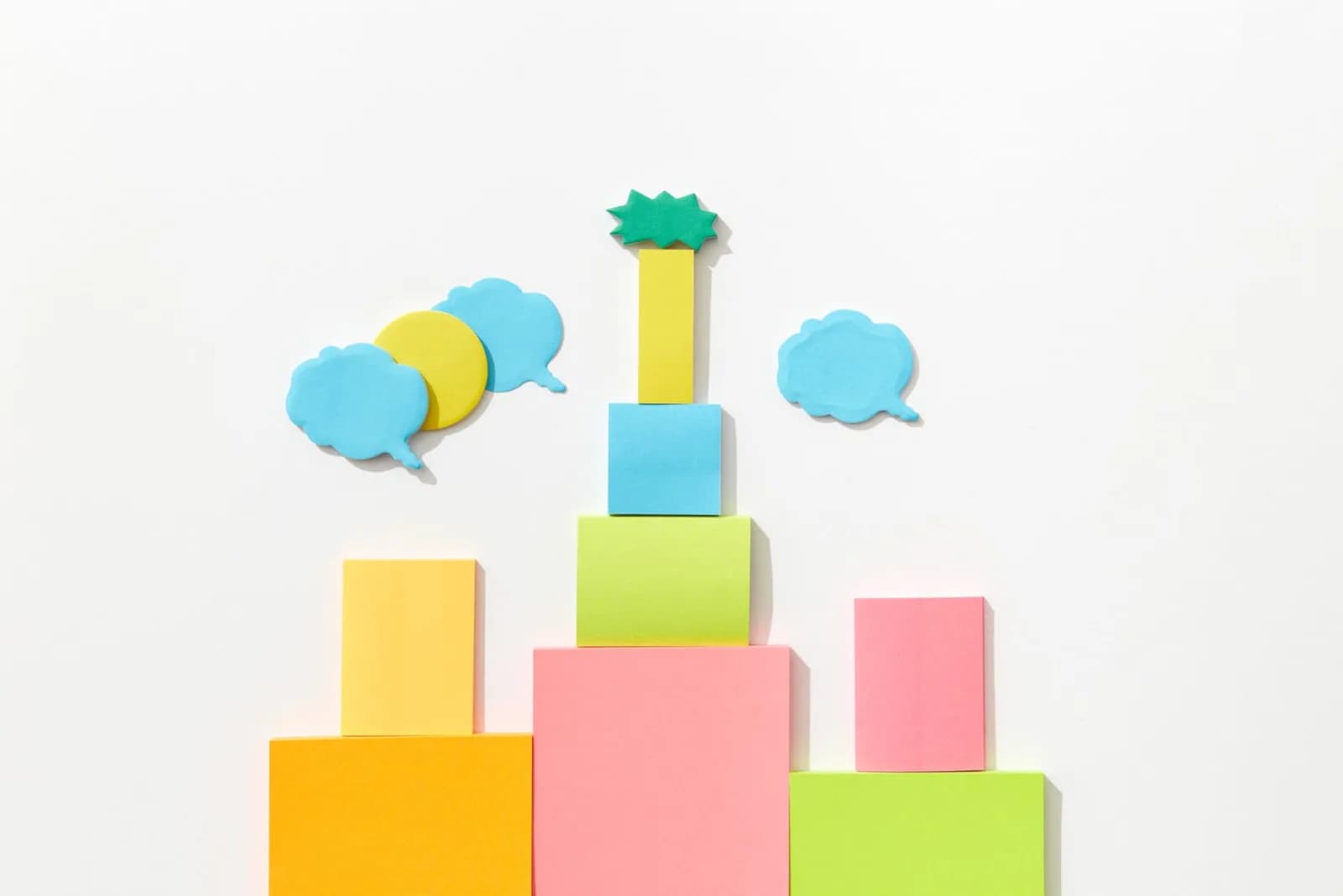 Stacked colorful paper shapes with speech bubbles on a white background, ideal for creative projects.