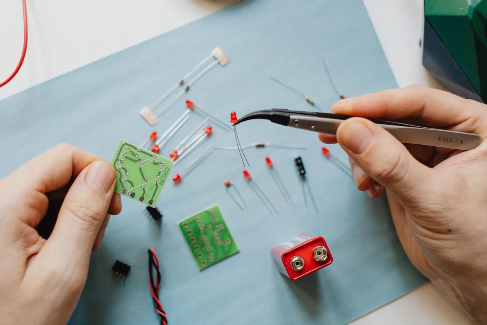 A close-up view of electronic repair with tools and circuit board components.