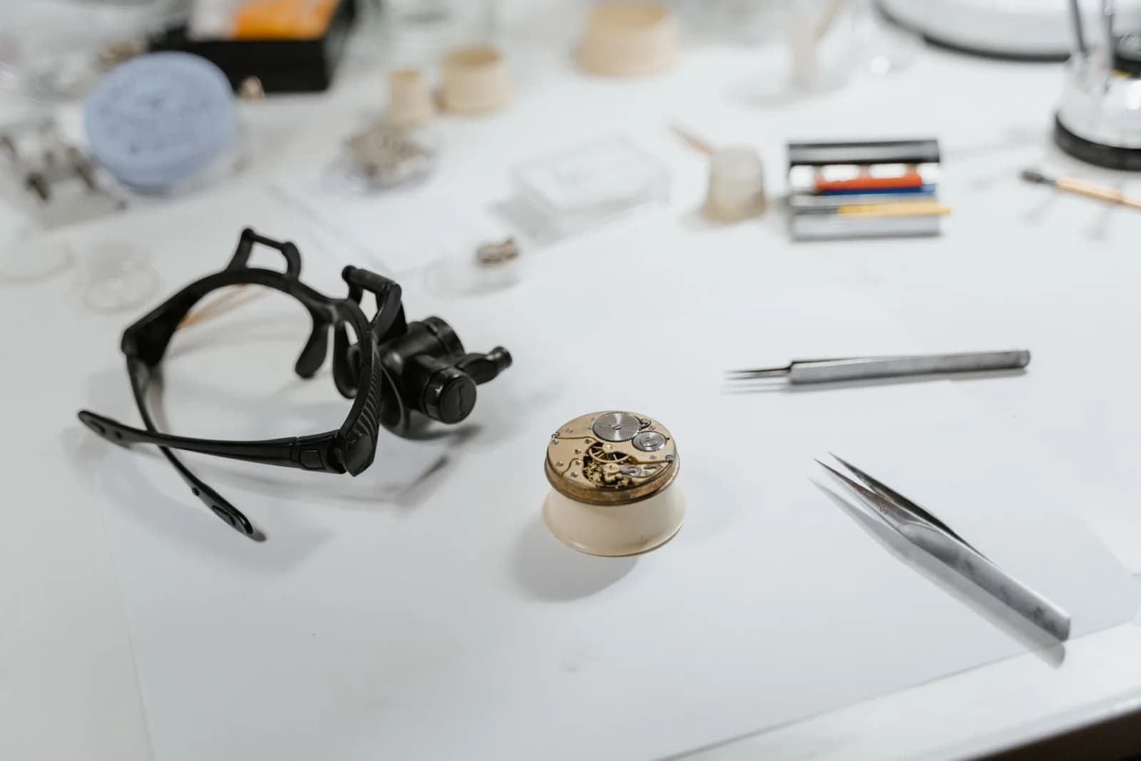 Detailed view of watchmaking tools and watch parts on a workbench, showcasing craftsmanship.