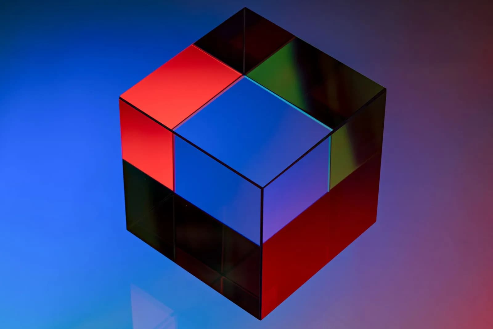 Colorful glass cube with reflective surfaces on a vibrant background, showcasing a modern abstract design.