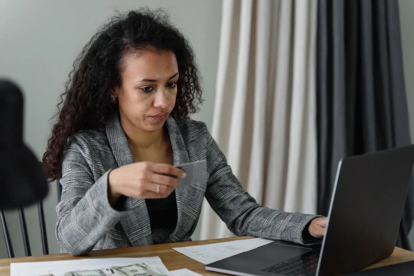 A woman paying online from her laptop with her card in hand
