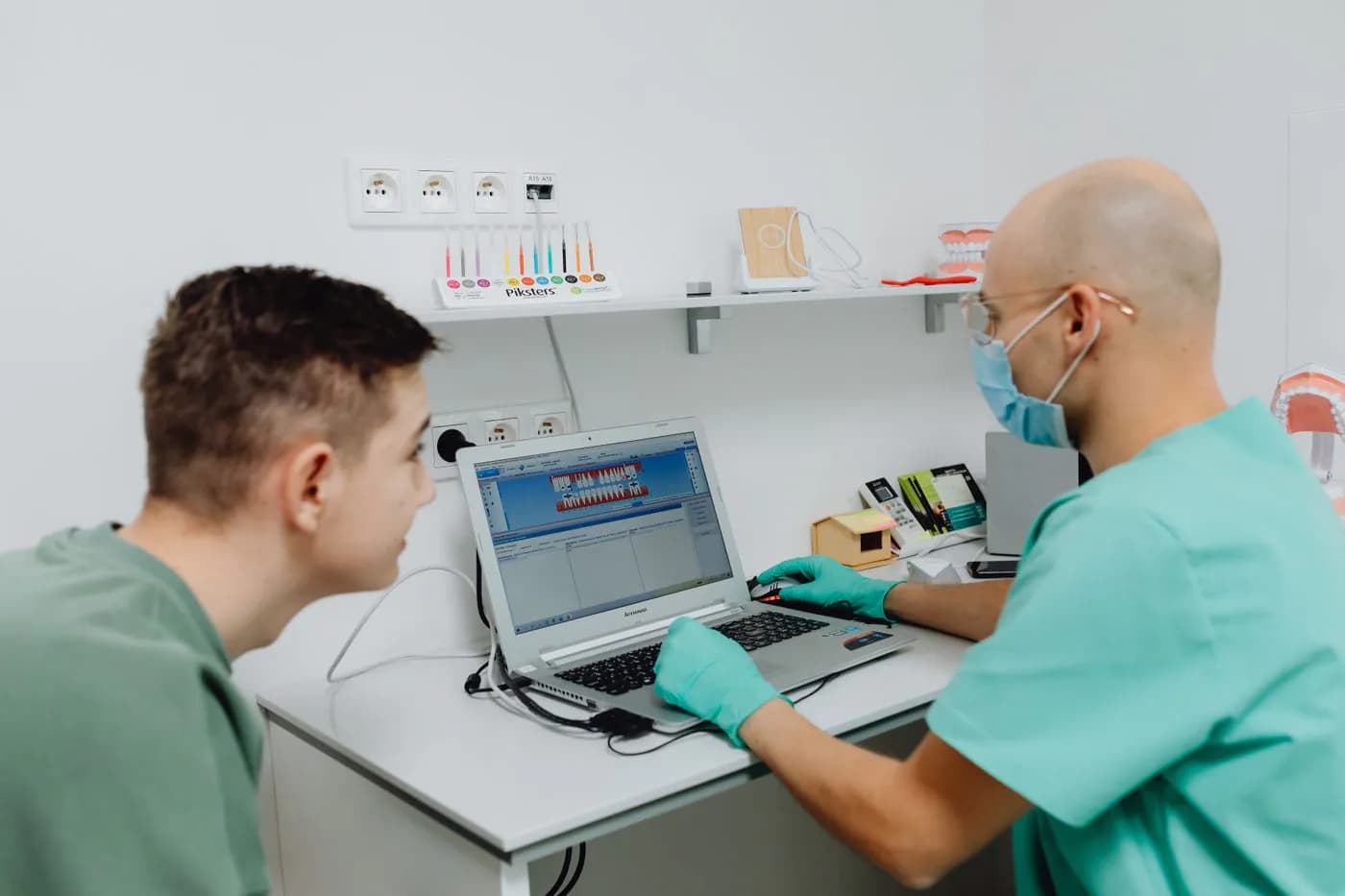 Two dental clinic staff working at the computer in the treatment room