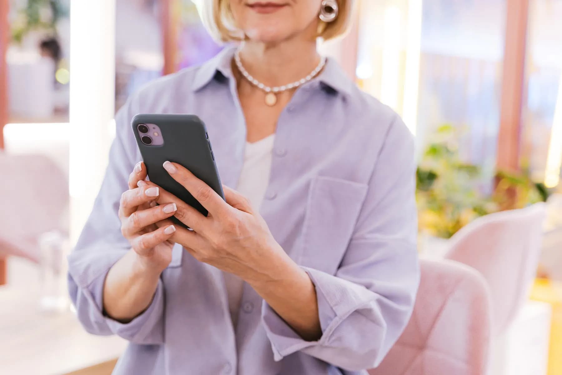 O femeie care verifică o aplicație pe telefon
