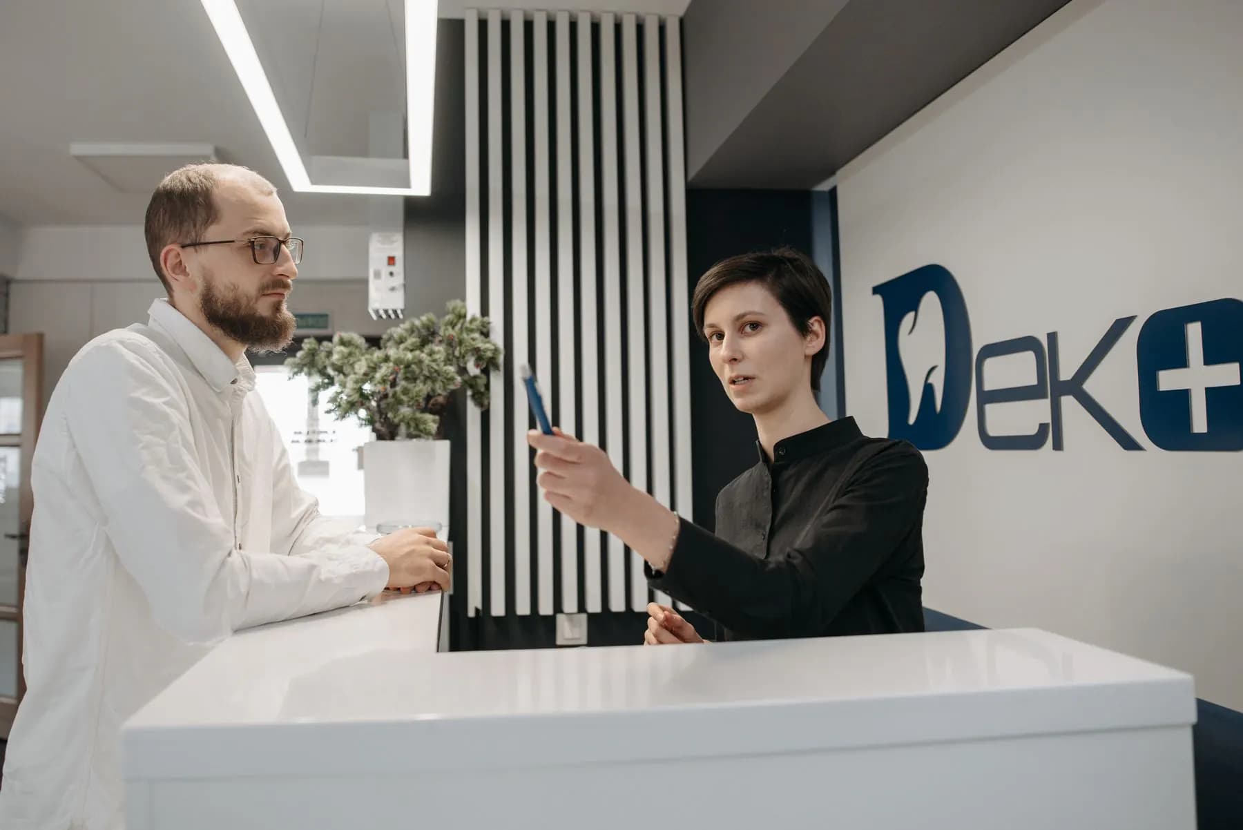 O recepționeră la recepția unei clinici, înregistrând o programare în persoană