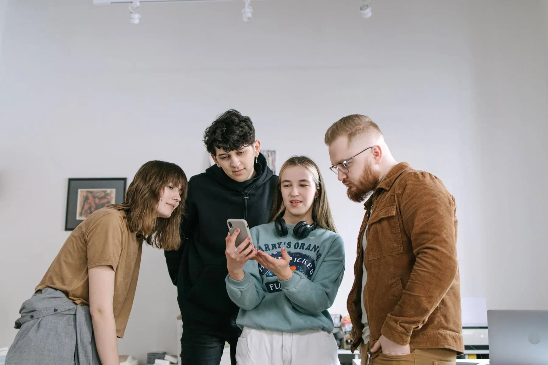 A small founding team gathered around a phone, testing the first version of their product