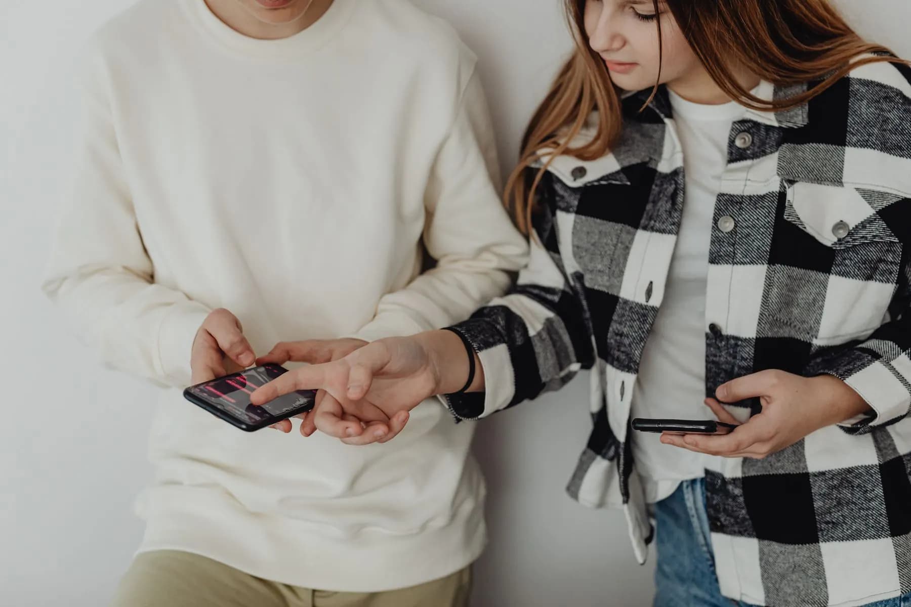 Two young people trying a new app together on their phones