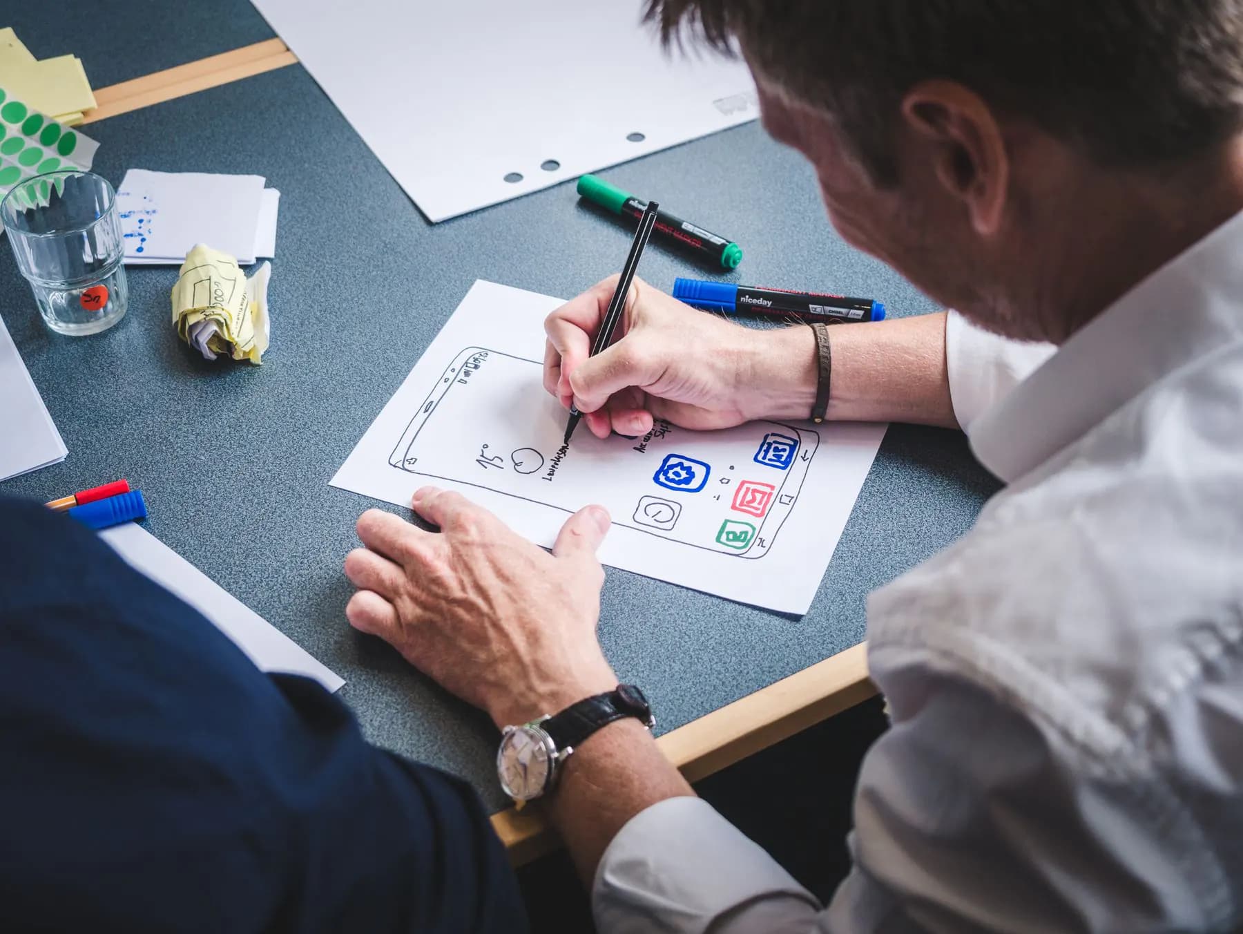 A designer sketching the screens of a mobile app on paper before anything is built