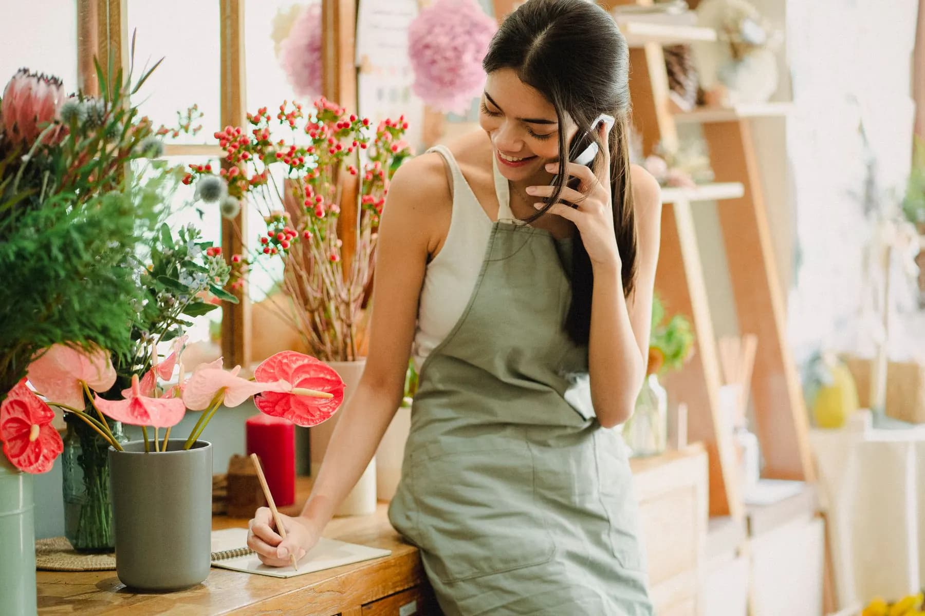A florist answering a customer call in the shop