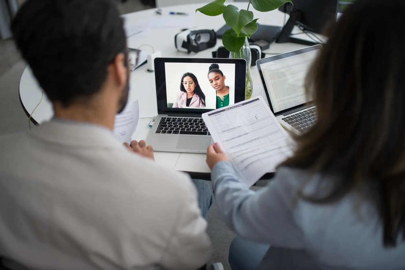 Two colleagues talking with a teammate on a video call
