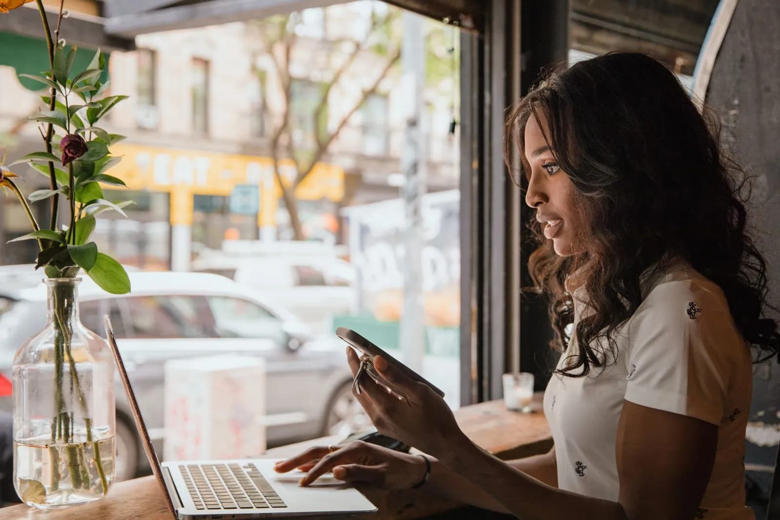 Un dirigeant travaillant sur un ordinateur portable et un téléphone dans un café
