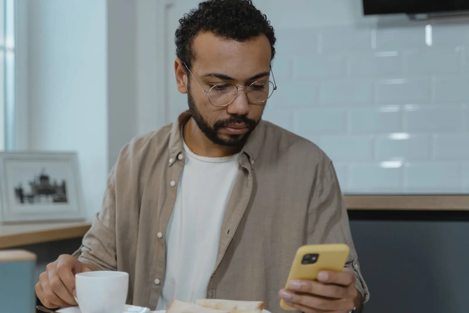 Un homme lisant sur son téléphone au petit-déjeuner