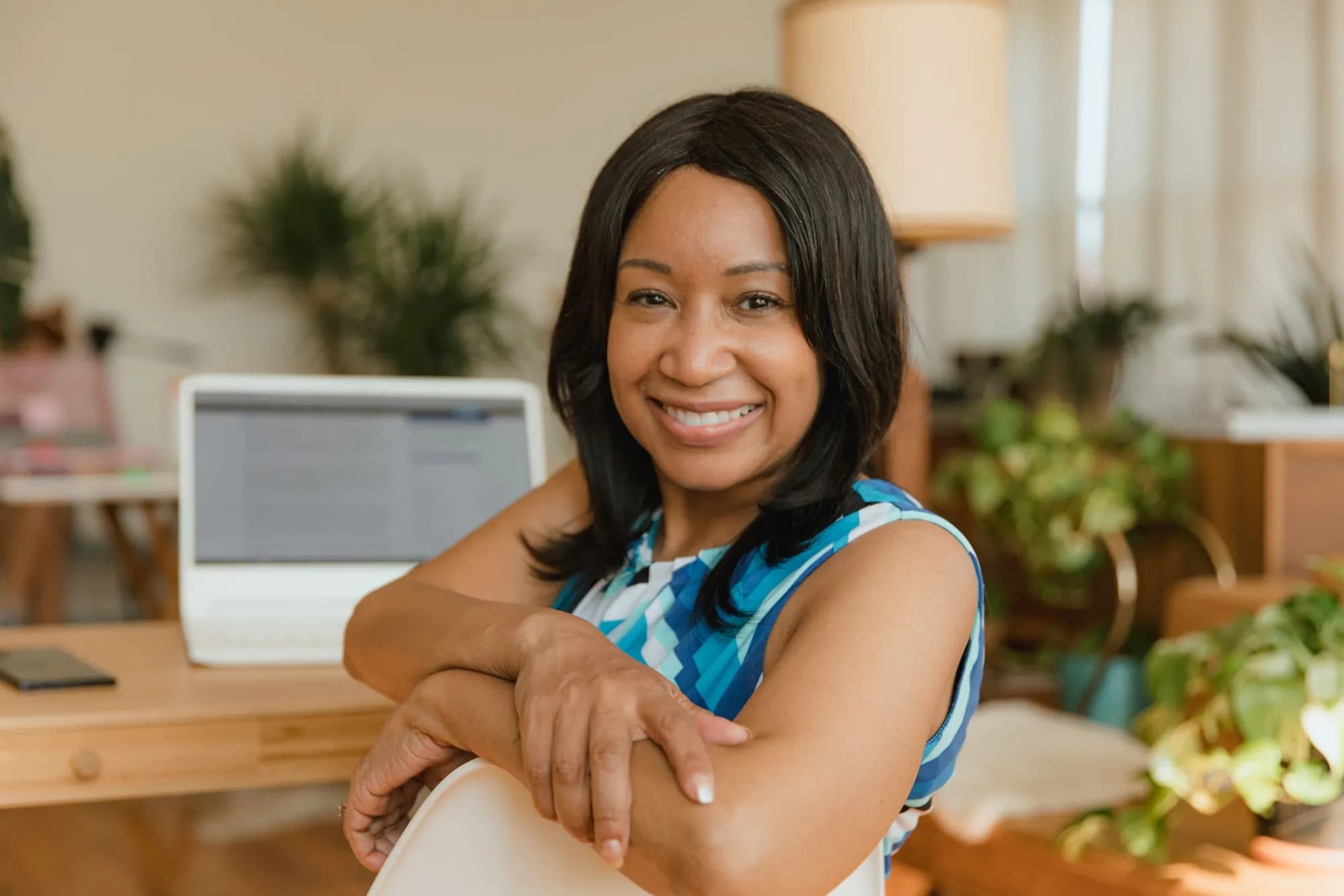 A smiling business owner at her desk in a bright office