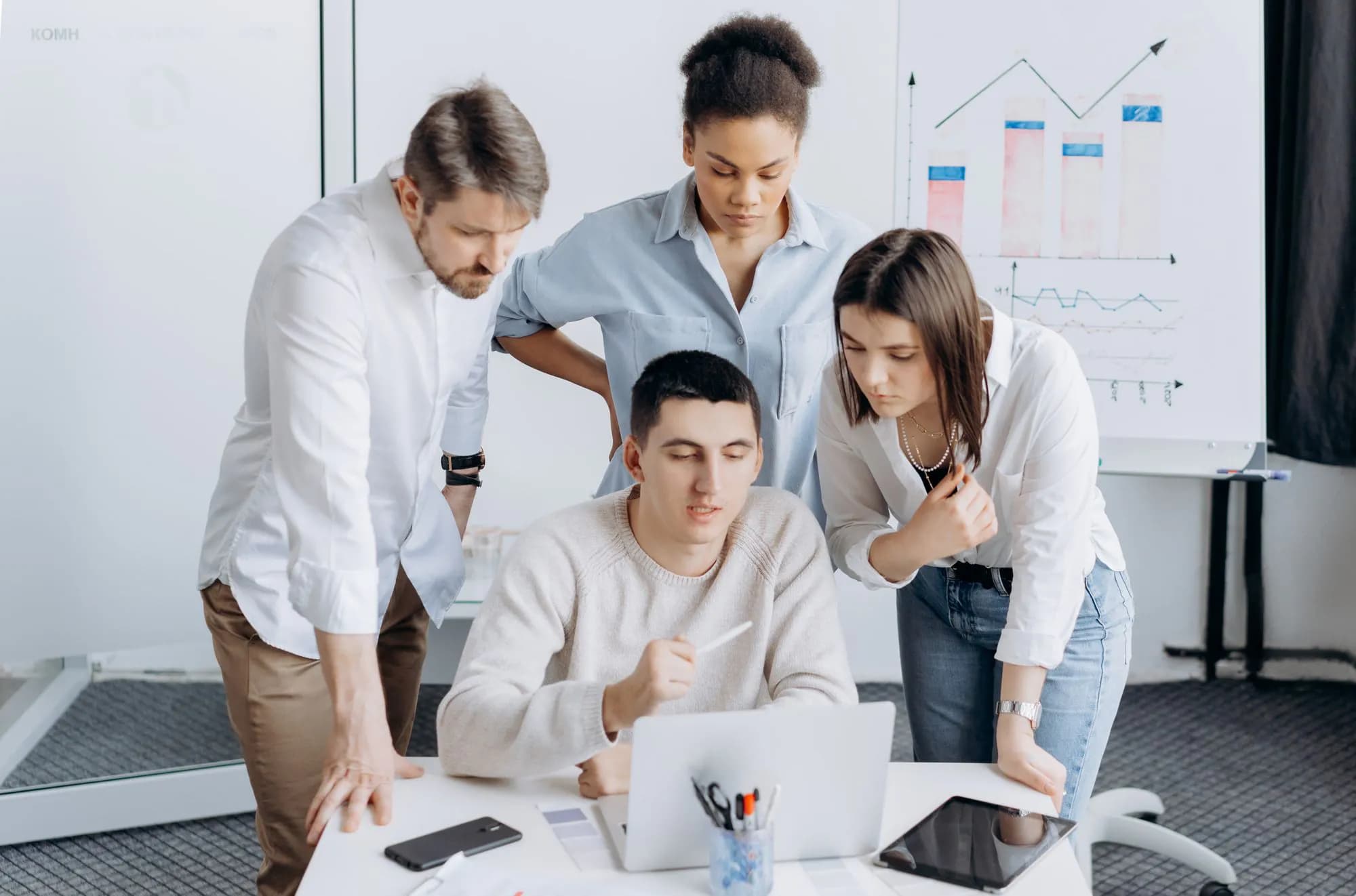 A team looking at growth charts together on a laptop