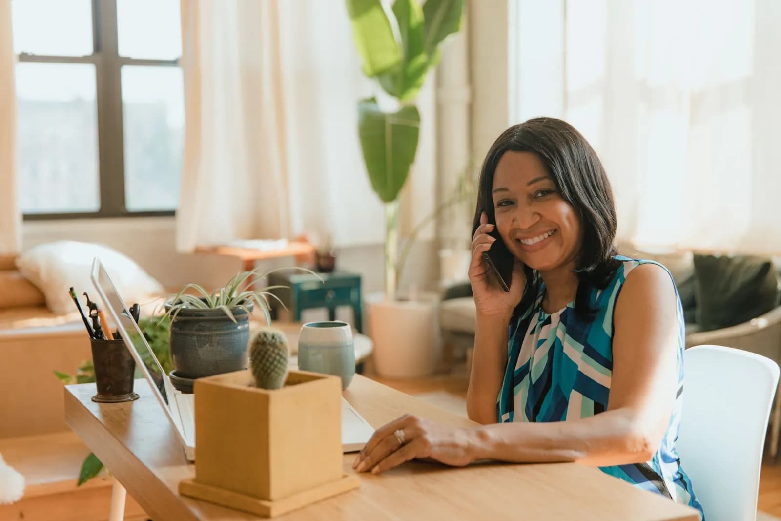 A smiling business owner on a call in her home office