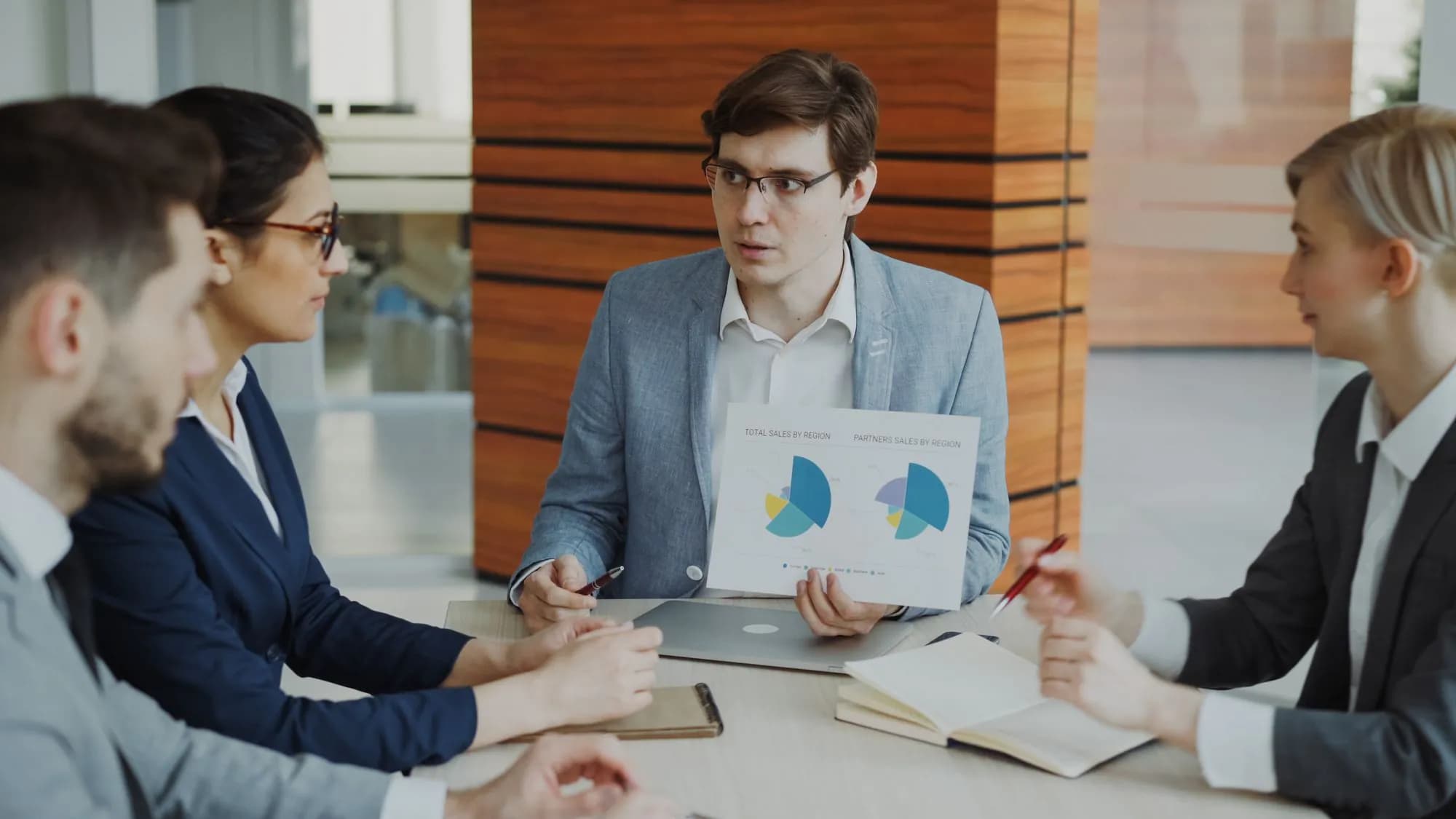 A team discussing charts and findings around a meeting table