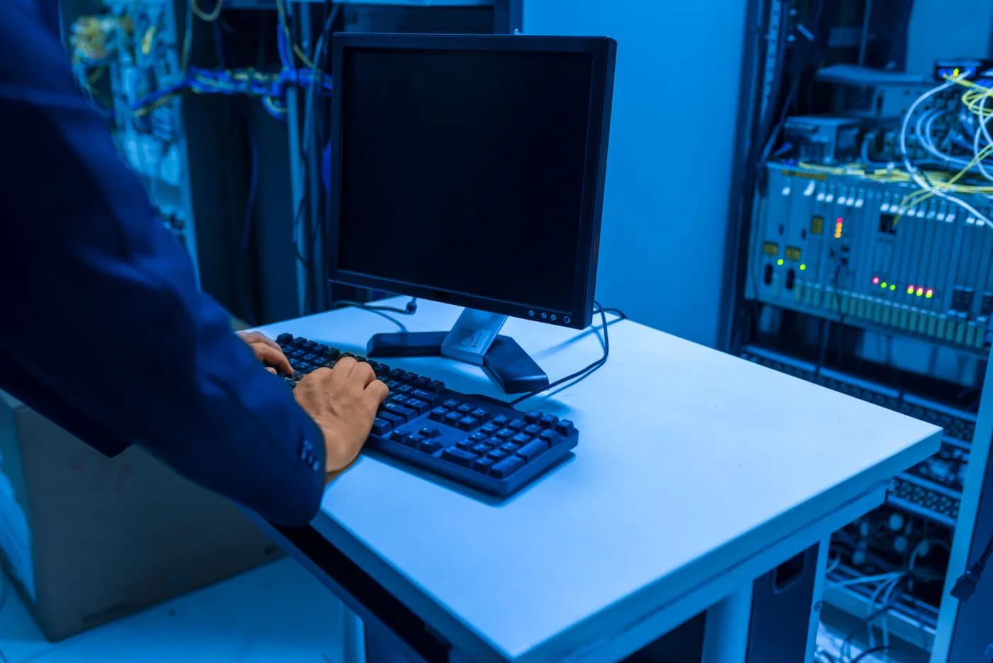 An engineer working at a computer in a server room