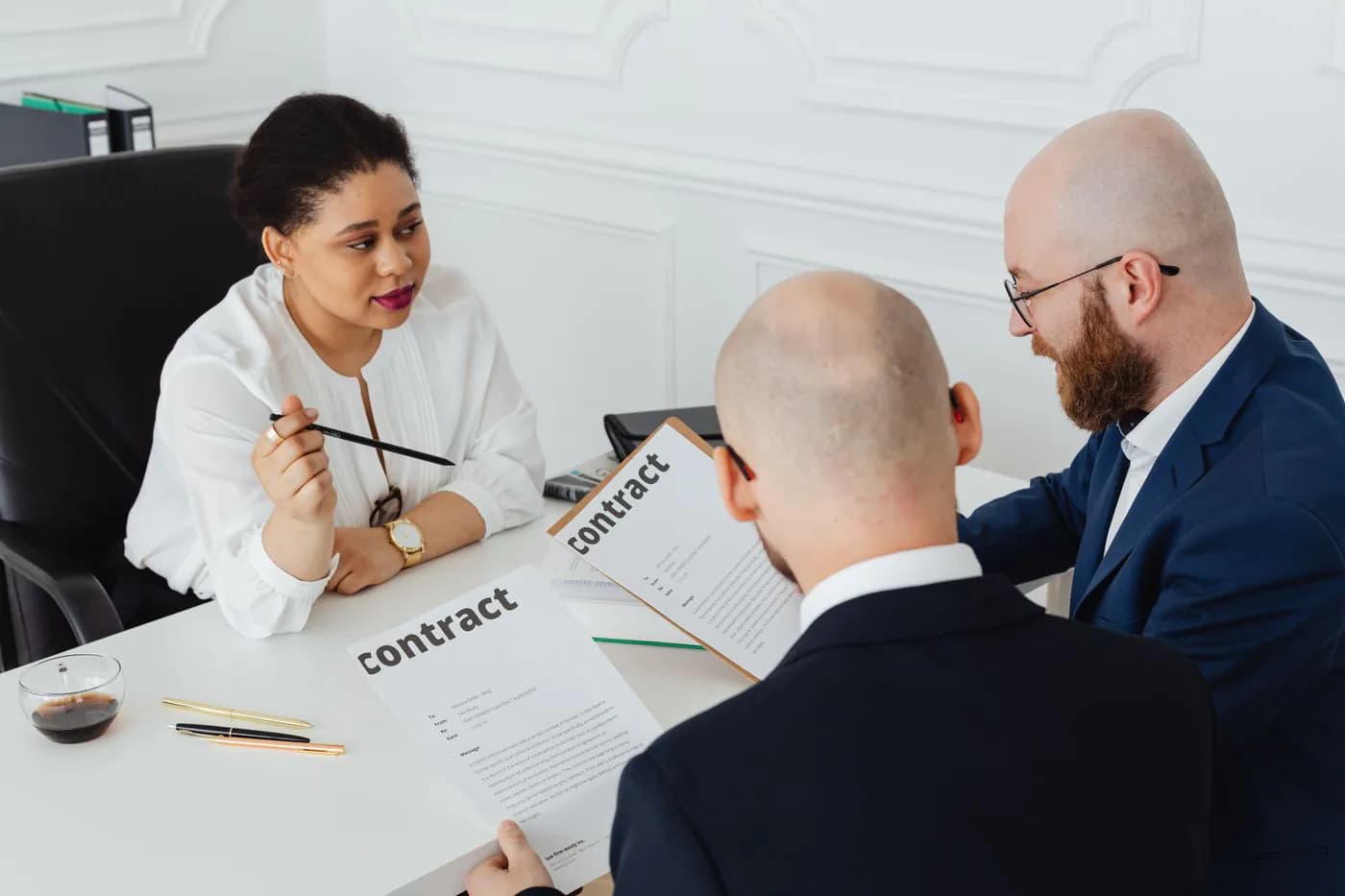 Three professionals going through a contract at a meeting