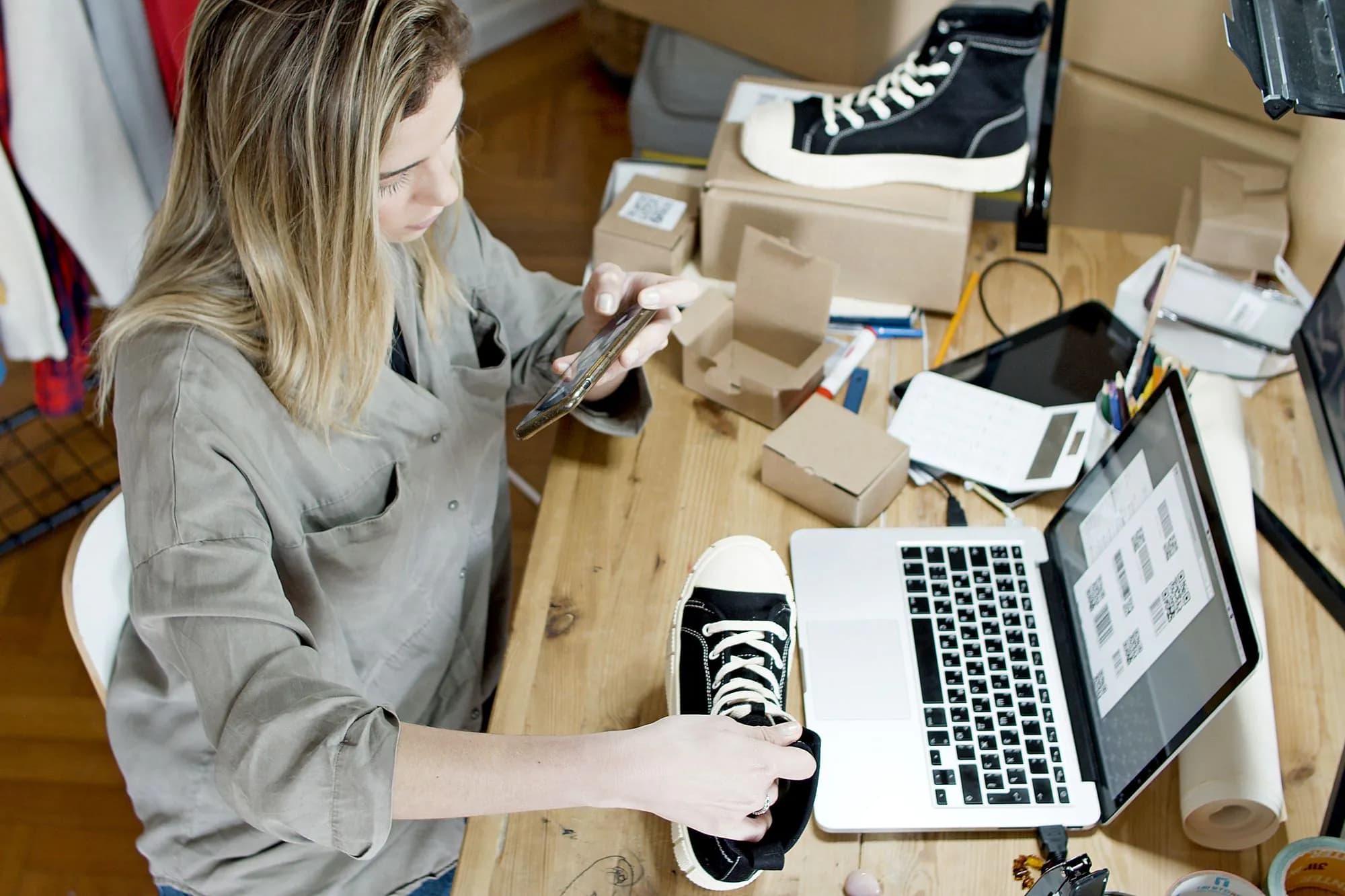 A business owner photographing products for her online shop at her workspace