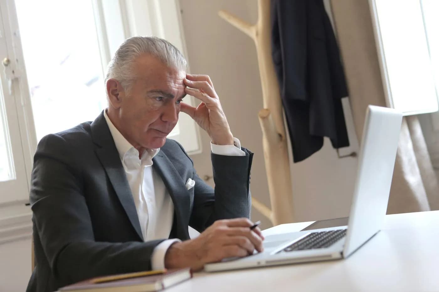 A senior manager frowning at an error on his laptop