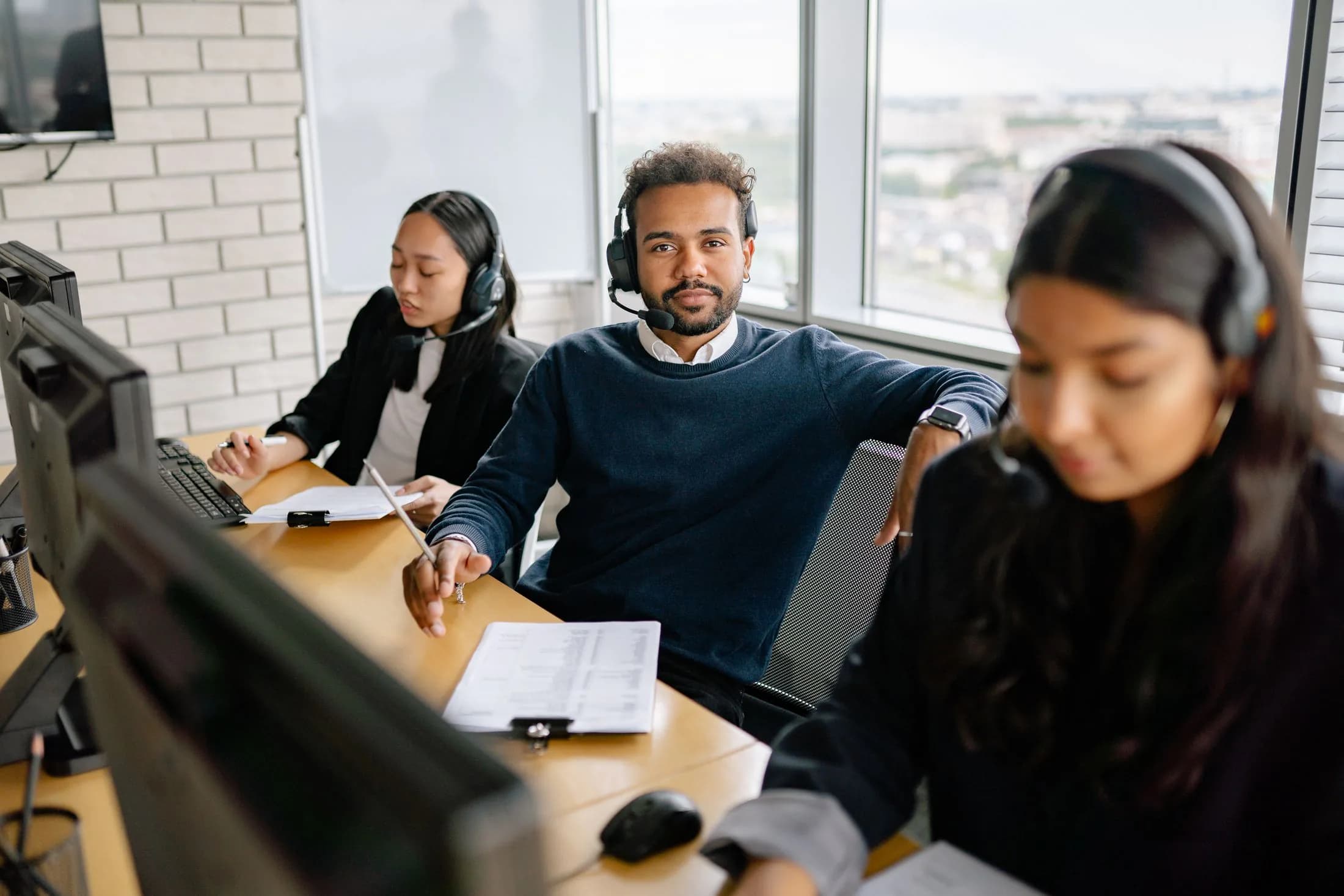 A support team on headsets working through requests at their desks