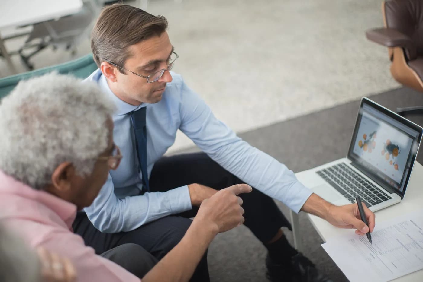 An adviser going through a laptop with an older business owner