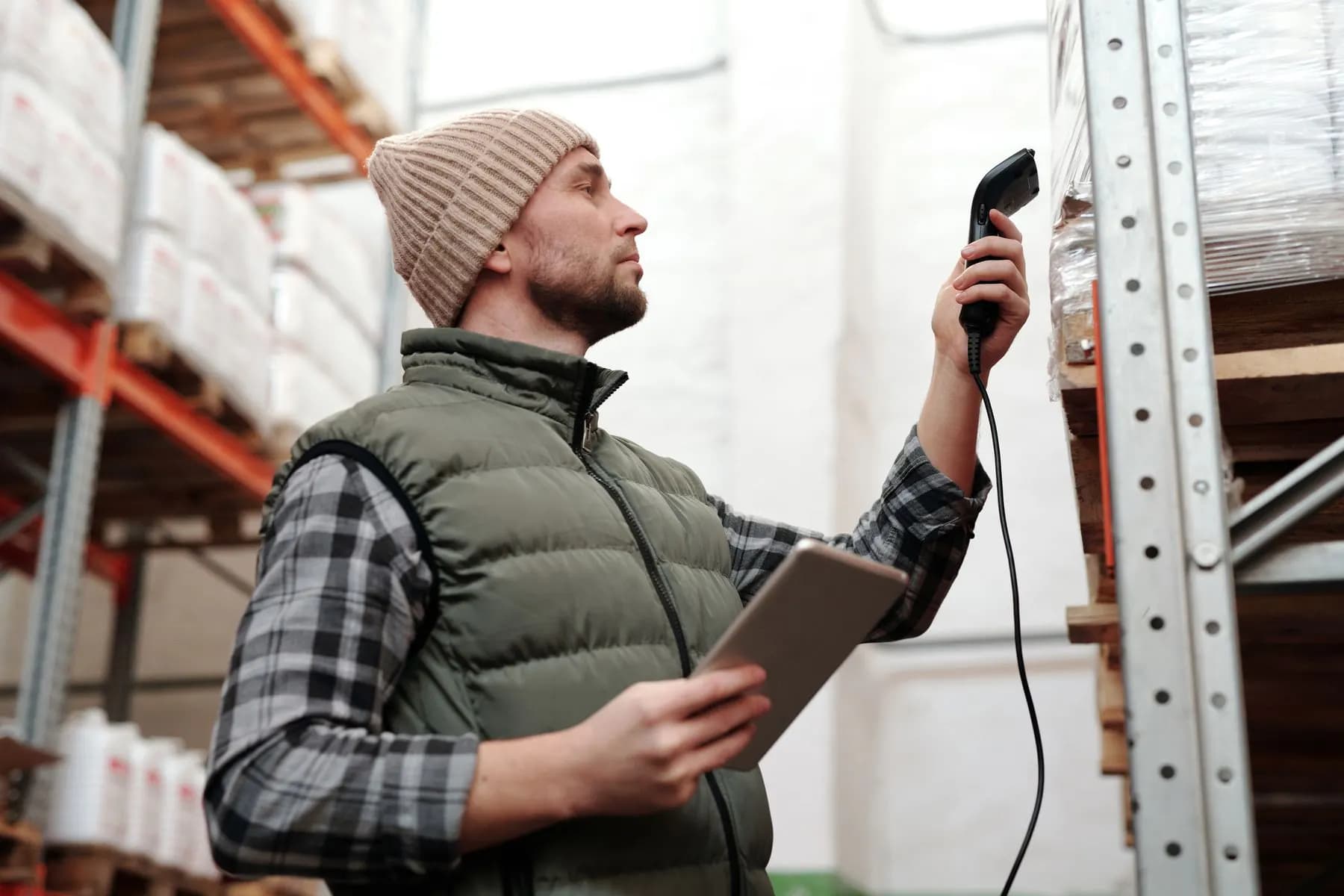 A warehouse team member scanning stock with a handheld scanner and a tablet