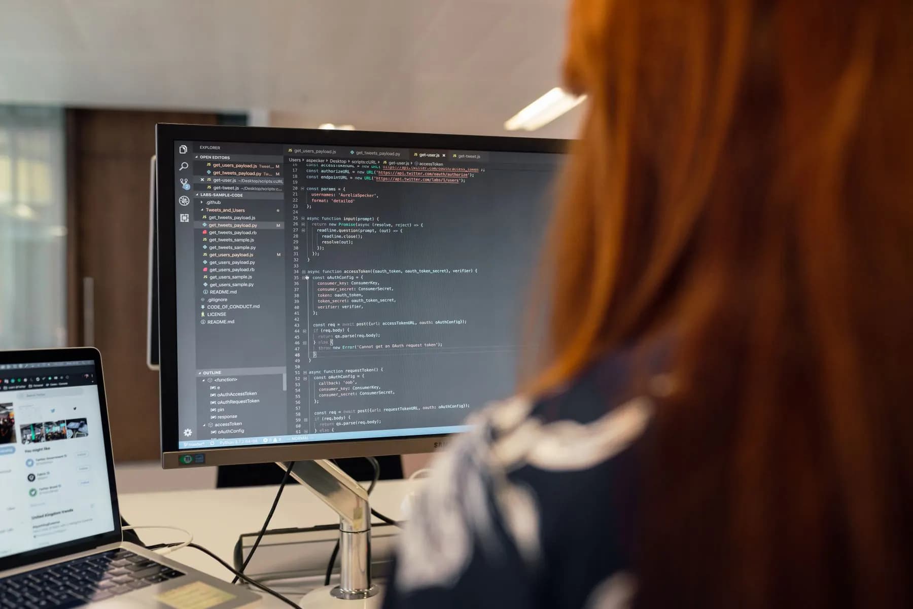 An engineer reviewing the code of an existing project on a large monitor