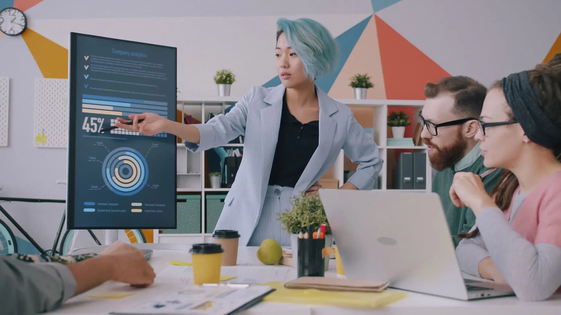 A team reviewing their product's numbers on a large screen in a meeting room