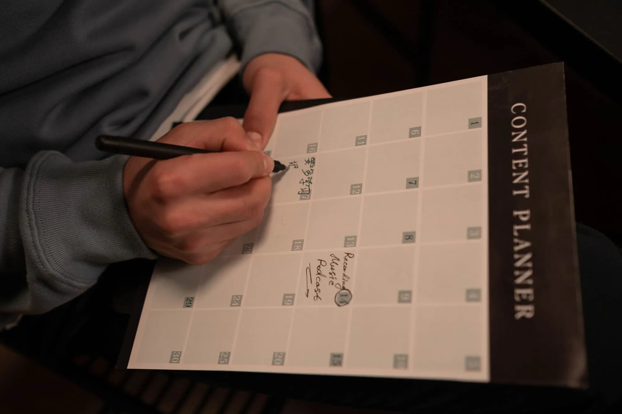 A hand writing in a content planner
