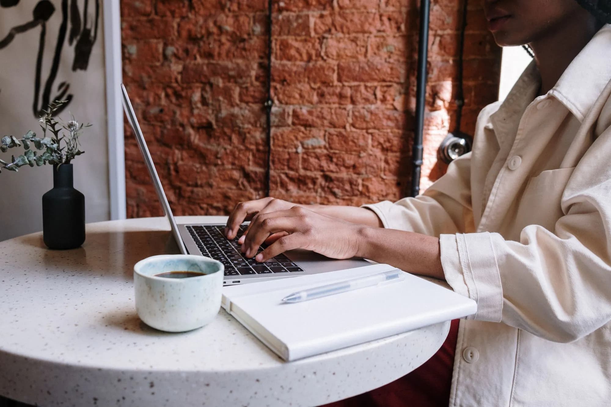 A woman working on a laptop in a cafe