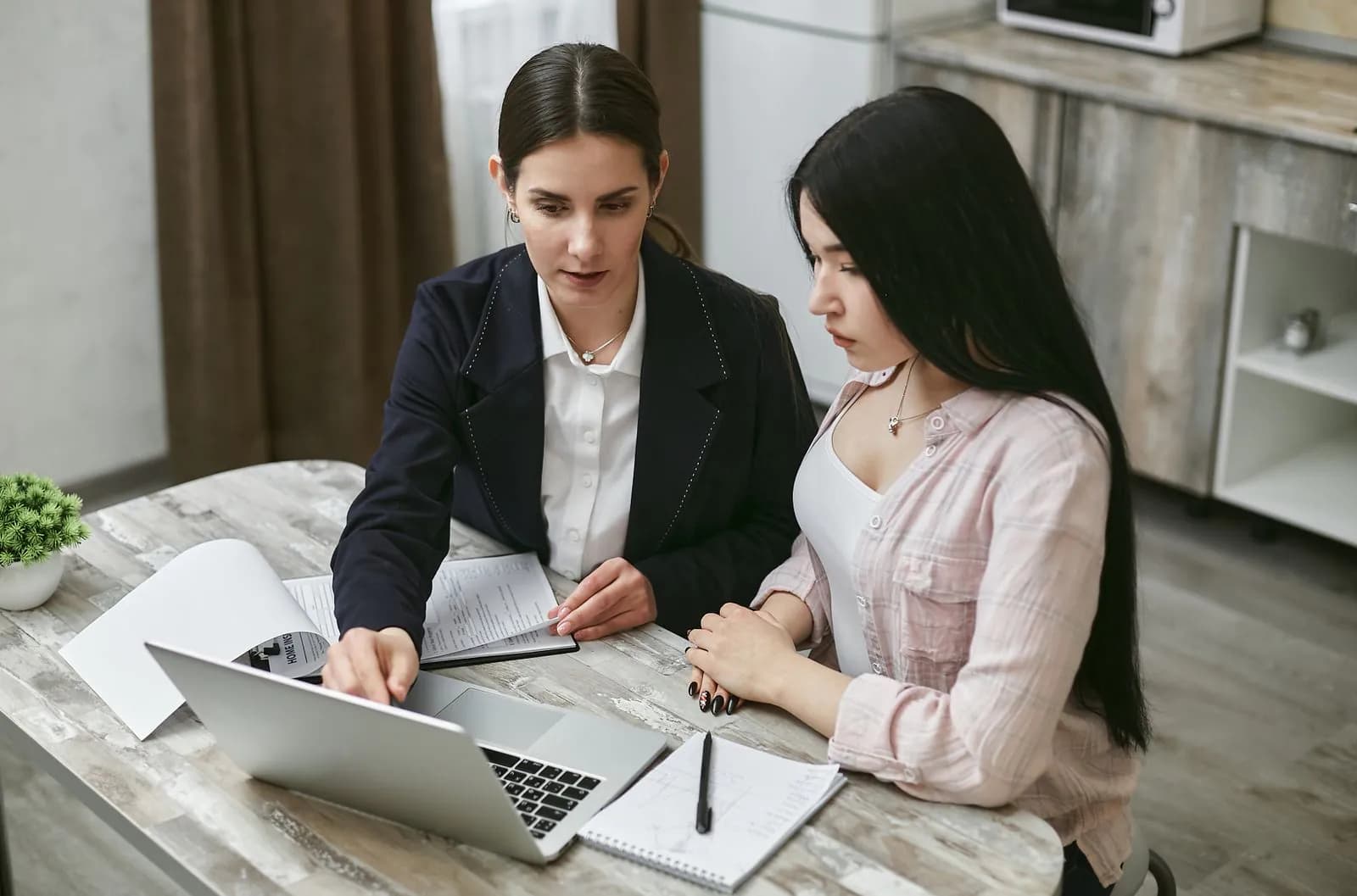 A business owner going over a plan with an adviser at a laptop
