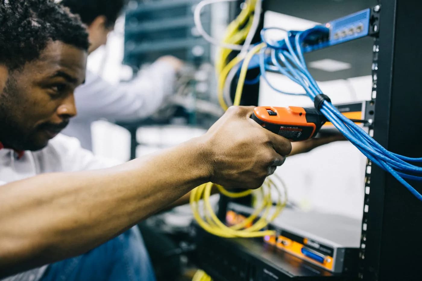 An engineer working on the cabling of a server rack
