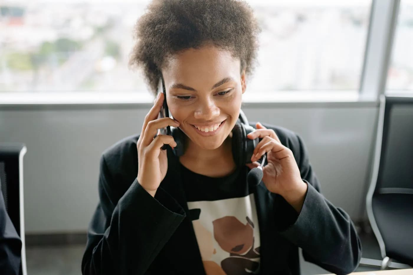 A support engineer smiling while talking with a client on the phone