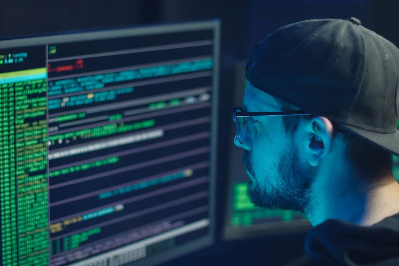 A security engineer checking lines of code on several screens